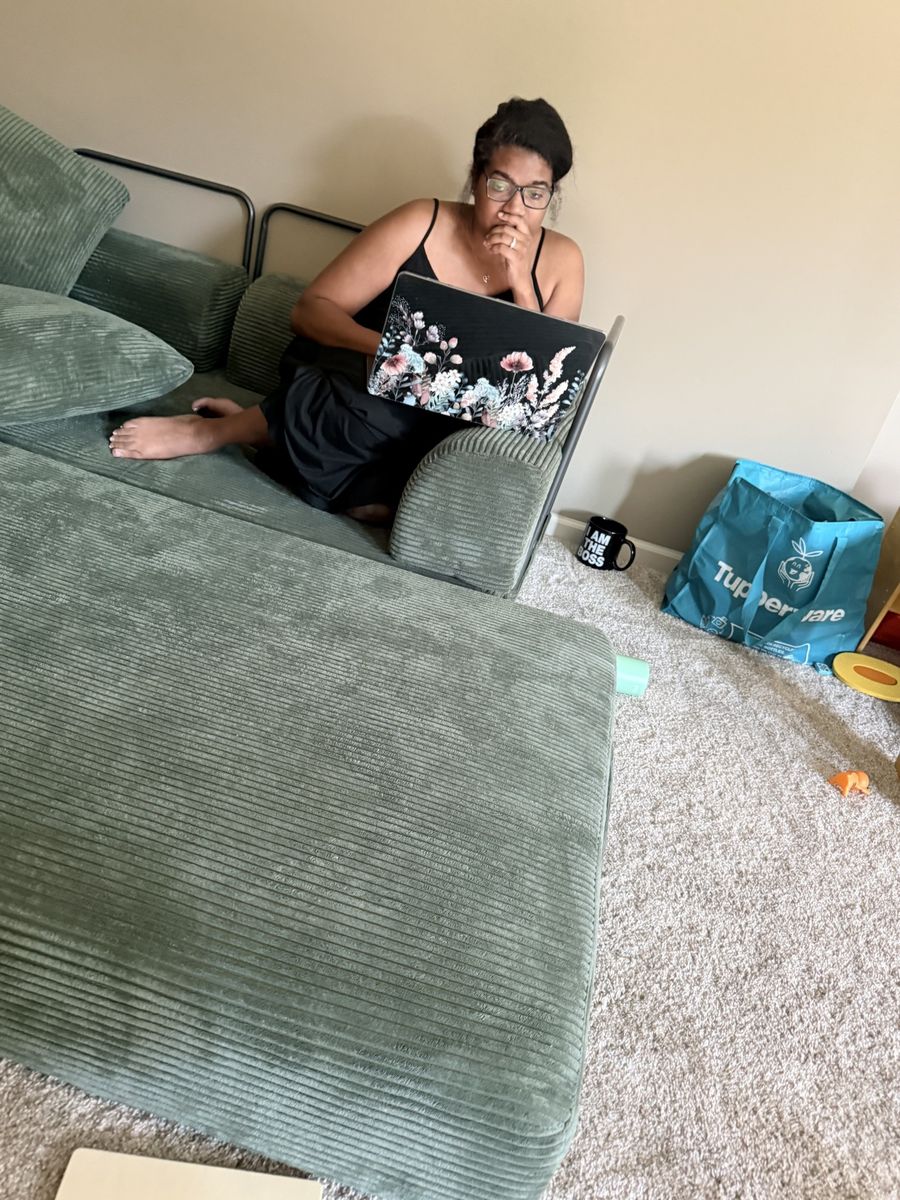 Jas working on her laptop on the couch — real work-from-home mom life